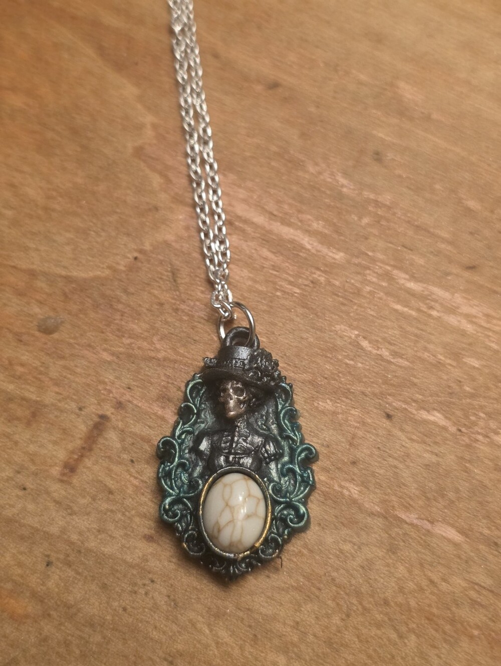 Green Gothic Skeleton Lady With A White Gemstone Center On A Silver Tone Chain